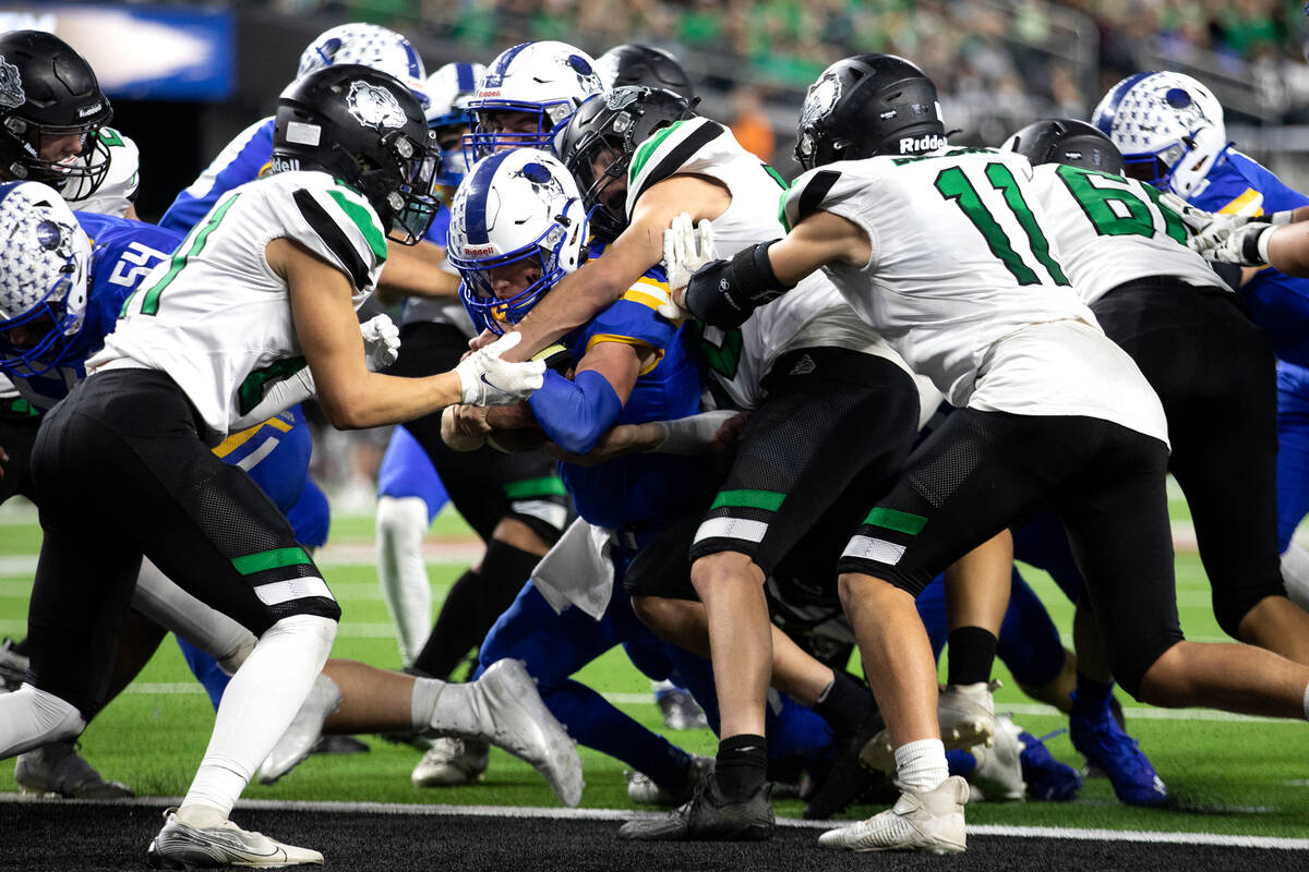 Moapa Valley quarterback Peyton Neilson (1) rushes through Virgin Valley defenders for a touchd ...