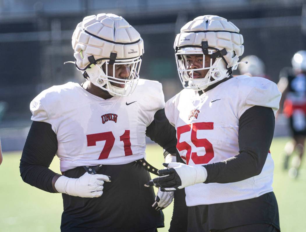 UNLV offensive linemen Daviyon McDaniel (71) and Preston Nichols (55) talk during football prac ...