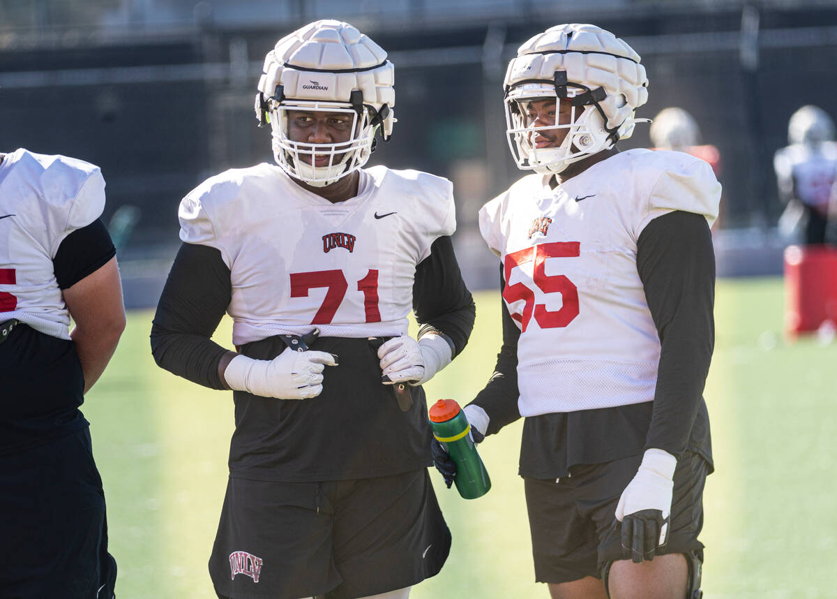 UNLV offensive linemen Daviyon McDaniel (71) and Preston Nichols (55) talk during football prac ...