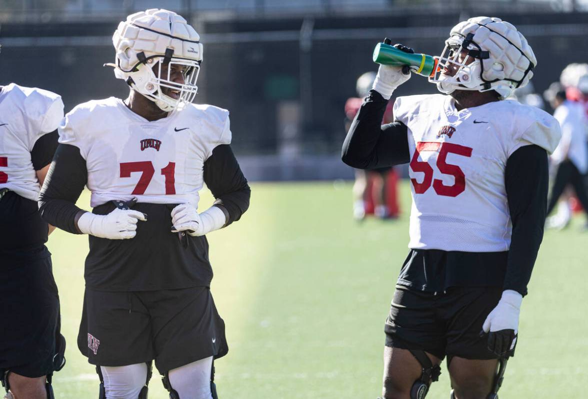 UNLV offensive linemen Daviyon McDaniel (71) and Preston Nichols (55) talk during football prac ...