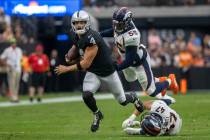 Raiders quarterback Derek Carr (4) tries to escape a tackle from Denver Broncos linebacker Brad ...
