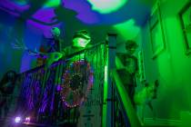 Evan Garcia, 10, walks his dog Jessie down the stairs of their Disney Halloween themed home, in ...