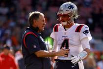 New England Patriots head coach Bill Belichick talks with quarterback Bailey Zappe (4) during a ...