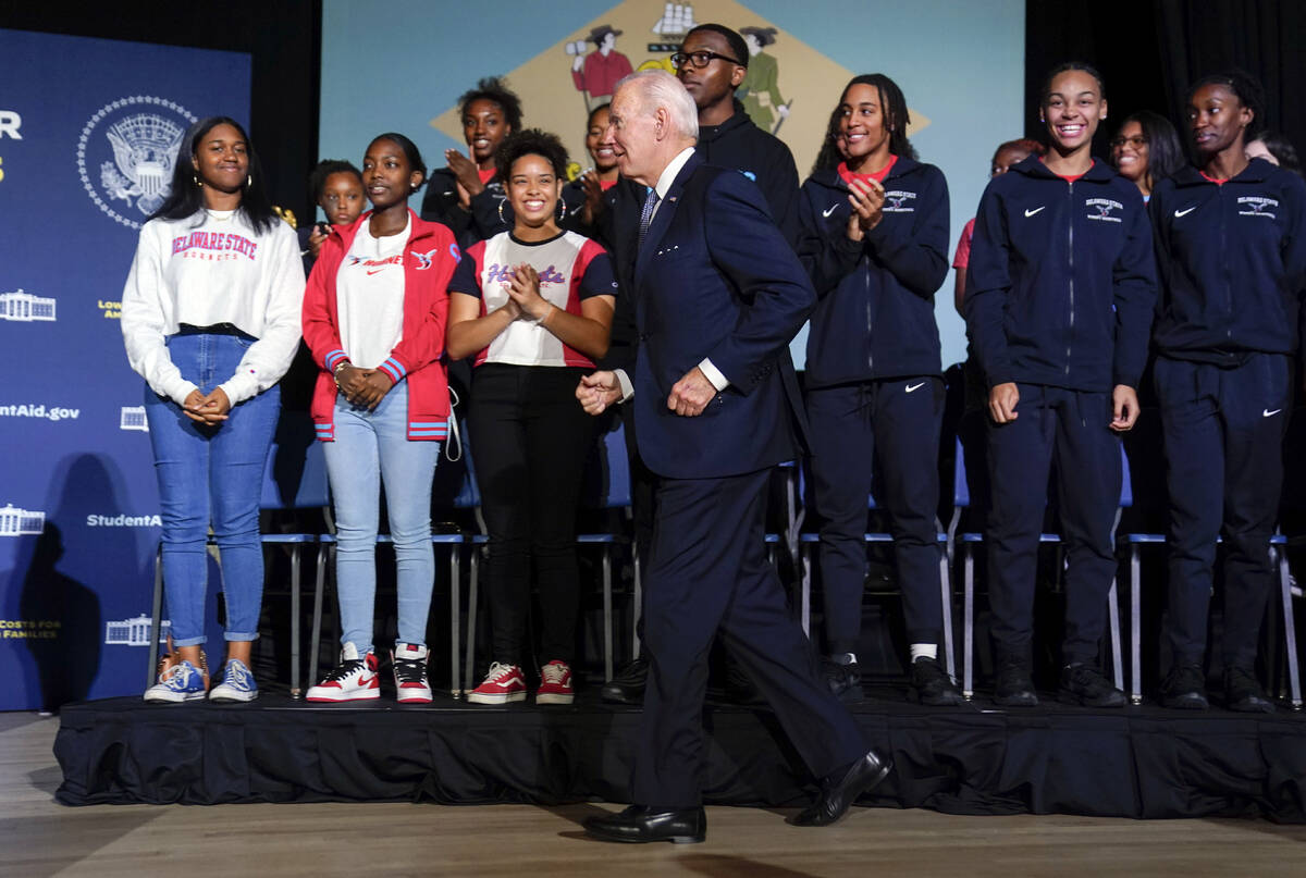 President Joe Biden jogs to the other side of the stage to talk with Delaware State University ...