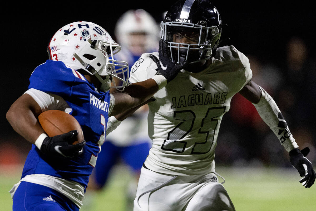 Liberty’s Isaiah Lauofo (3) pushes away Desert Pines’ Jaylen Allen (25) as he nea ...