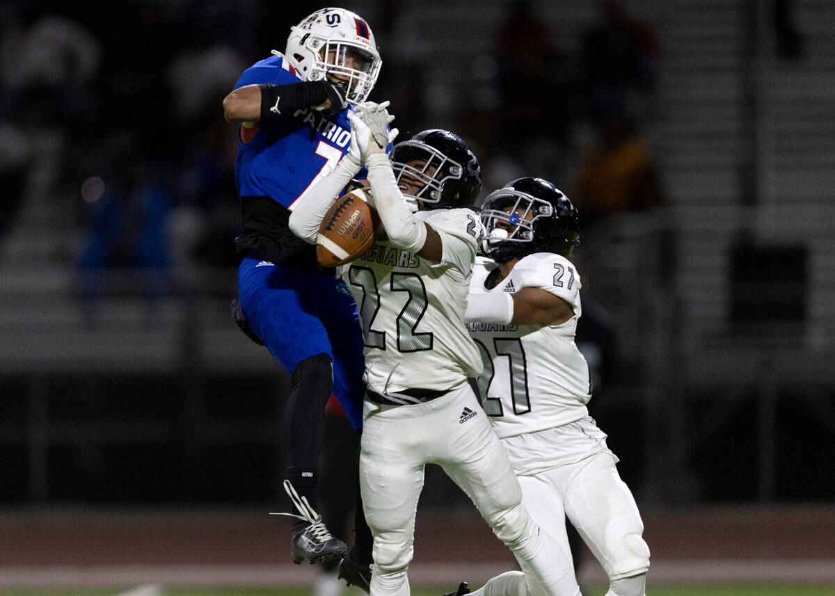 Liberty’s Jayden Robertson (7) jumps to catch a touchdown pass while Desert Pines’ ...