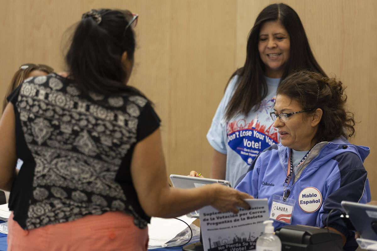 Clark County Election Department employee Carmen Anaya, left, and poll worker Laura Sanchez, as ...
