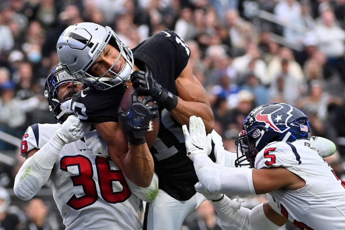 Las Vegas Raiders wide receiver Mack Hollins, center, hauls in a pass for a touchdown between H ...