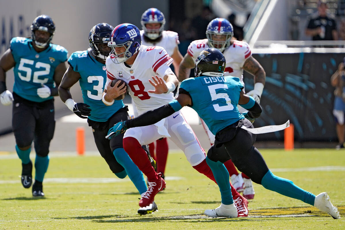 New York Giants quarterback Daniel Jones (8) tries to elude Jacksonville Jaguars safety Andre C ...