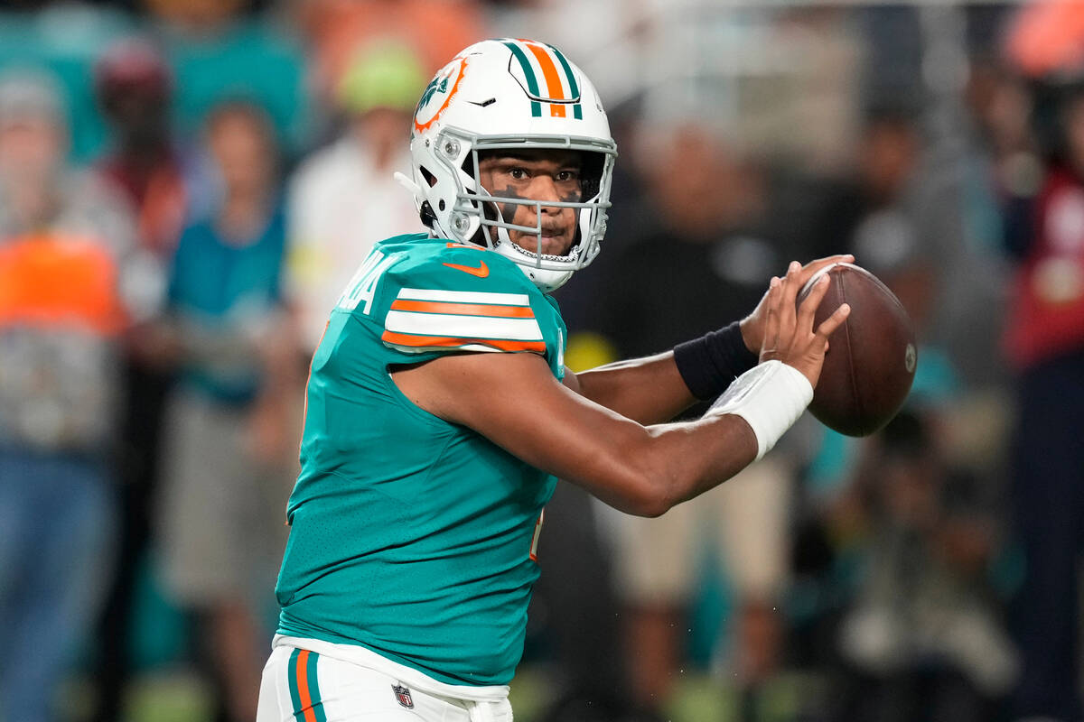 Miami Dolphins quarterback Tua Tagovailoa (1) aims a pass during the first half of an NFL footb ...