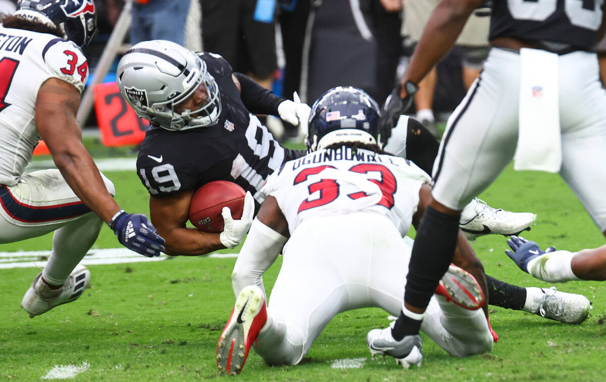 Raiders wide receiver DJ Turner (19) is tackled by the Houston Texans during the first half of ...