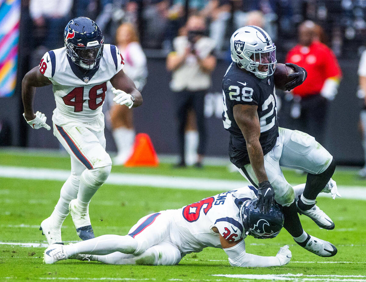 Raiders running back Josh Jacobs (28) is tackled from behind by Houston Texans safety Jonathan ...