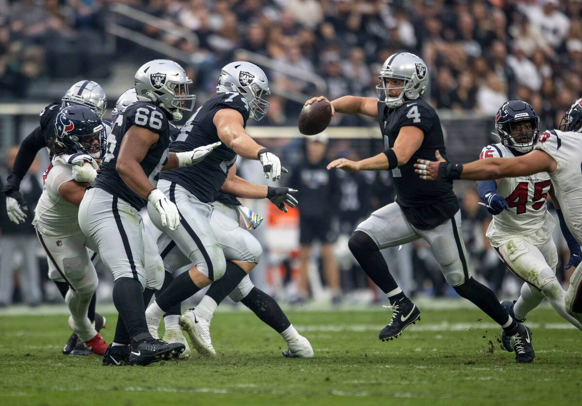 Raiders quarterback Derek Carr (4) scrambles to avoid being tackled by Houston Texans linebacke ...