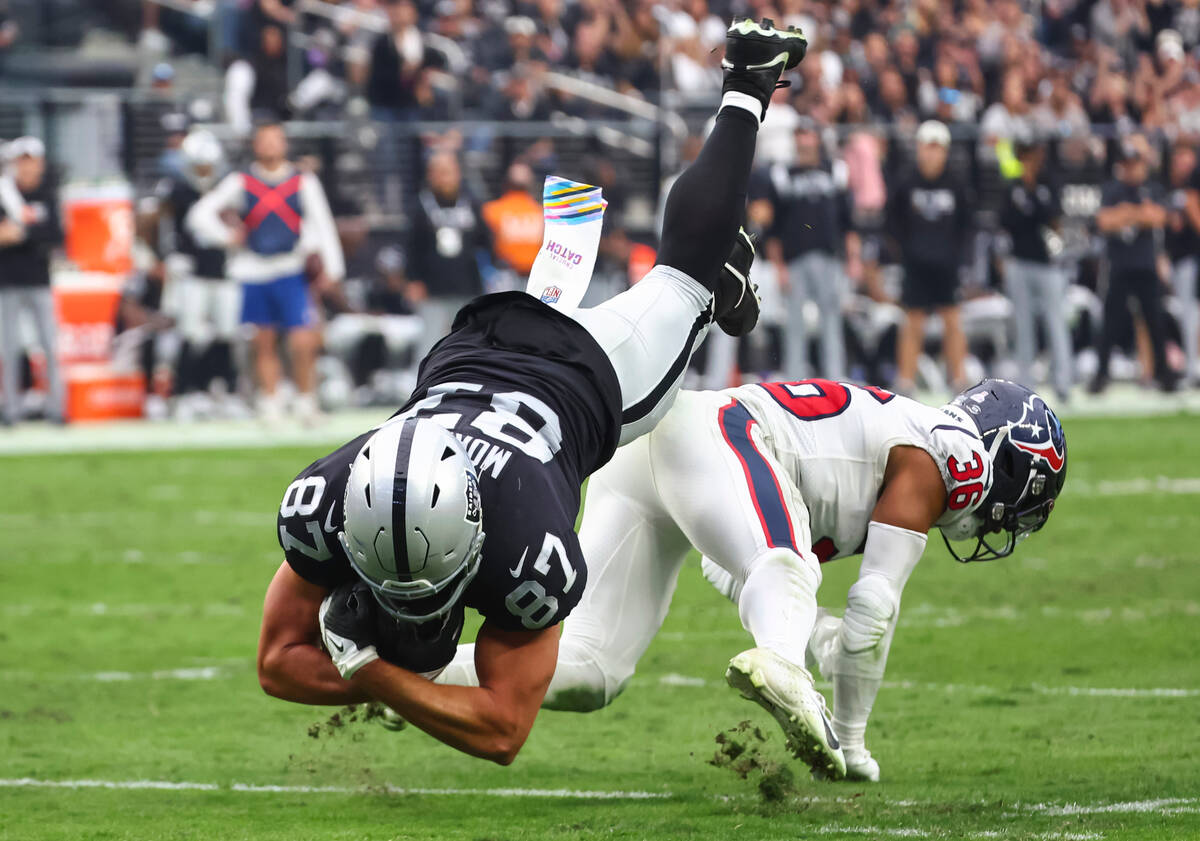 Raiders tight end Foster Moreau (87) leaps over Houston Texans safety Jonathan Owens (36) durin ...