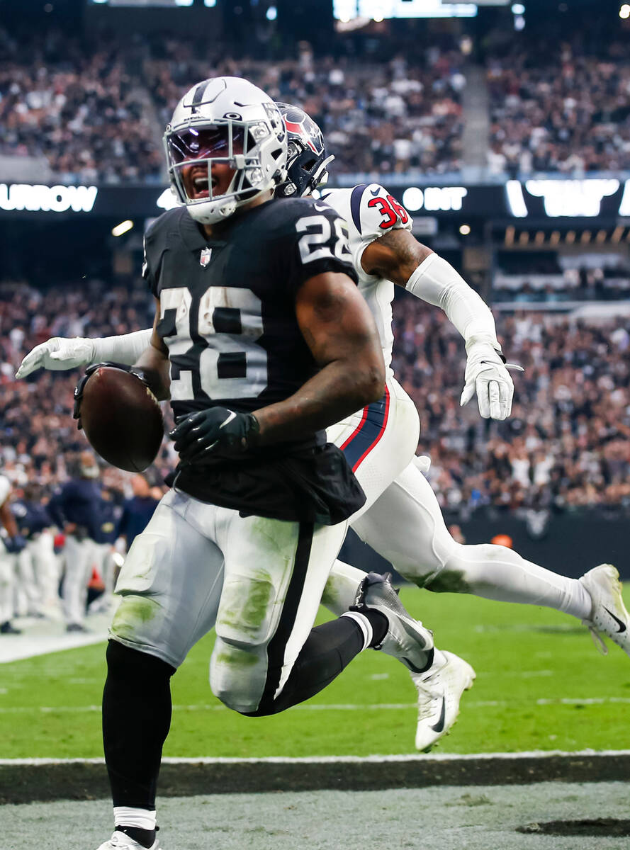 Raiders running back Josh Jacobs (28) gets past Houston Texans safety Jonathan Owens (36) to sc ...