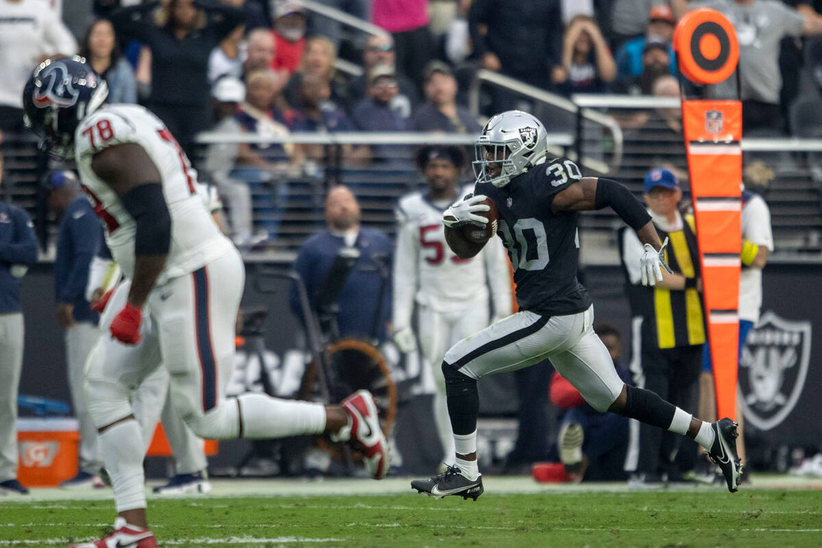 Raiders safety Duron Harmon (30) runs for the end zone after grabbing an interception with Hous ...