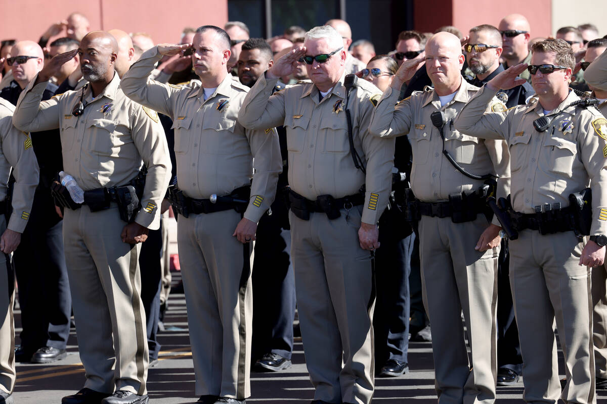 Metropolitan Police Department officers salute as the procession for fallen Las Vegas police of ...