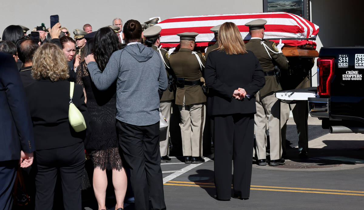 Family members watch as honor guard members load the casket for fallen Las Vegas police officer ...