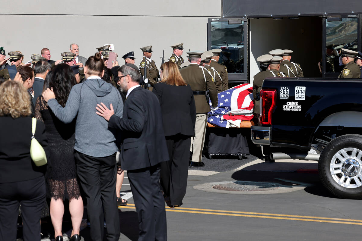 Family members watch as honor guard members load the casket for fallen Las Vegas police officer ...