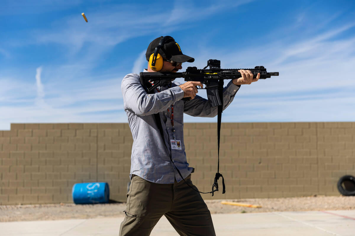 Review-Journal reporter Brett Clarkson fires an M4 variant carbine during a range day held by t ...
