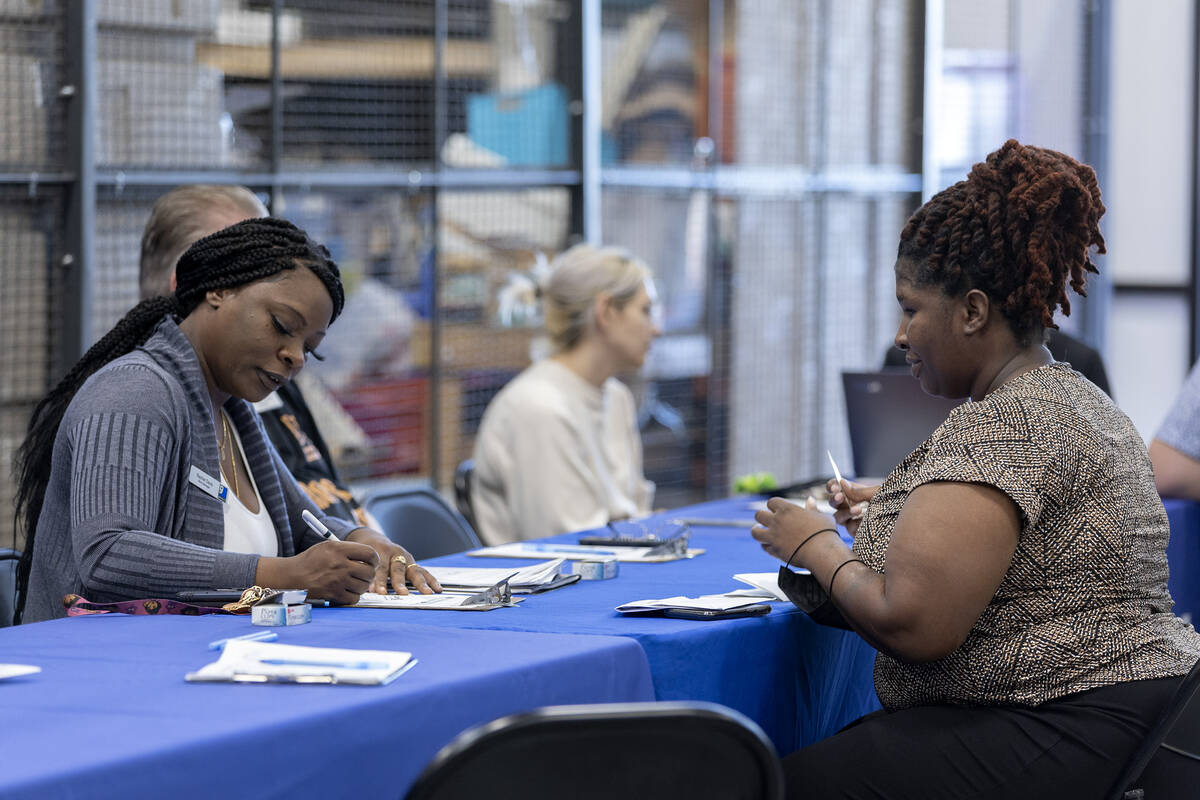 Store manager Rachel Davis speaks with potential employee Ashley Maye during a hiring event at ...