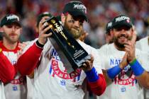Philadelphia Phillies designated hitter Bryce Harper celebrates with the trophy after winning t ...