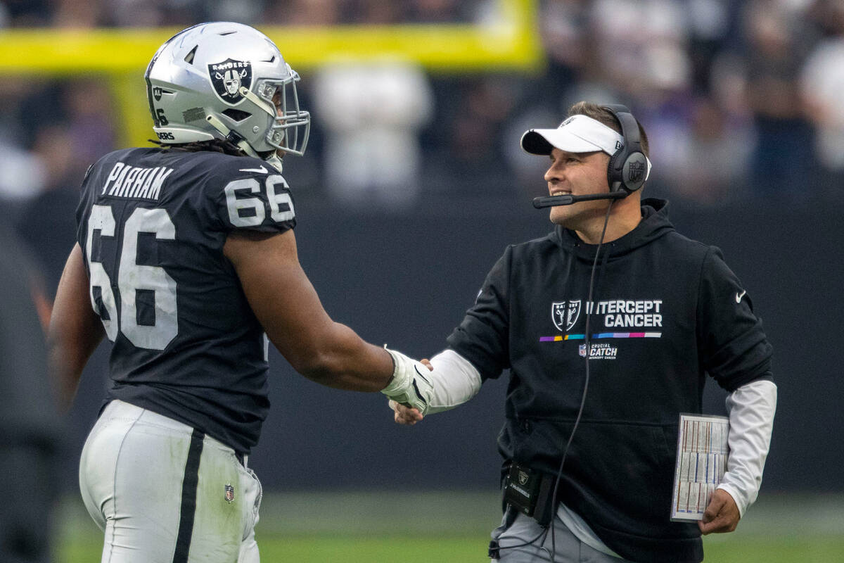 Raiders head coach Josh McDaniels smiles as he greets offensive lineman Dylan Parham (66) after ...