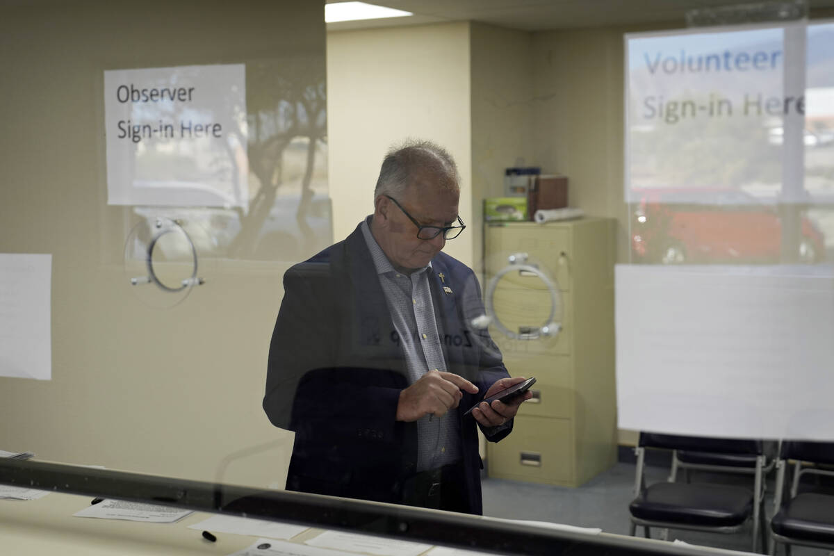 Interim Nye County Clerk Mark Kampf works on his phone in an office where early votes are being ...