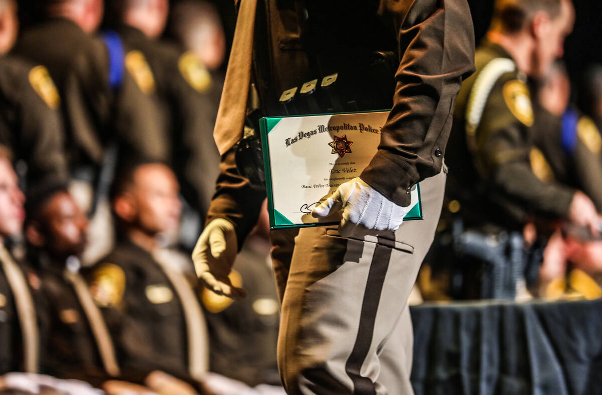 Graduate Eric Velez leaves the stage with his diploma at the Metropolitan Police Department’s ...