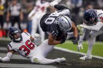Raiders wide receiver Mack Hollins (10) scores over Houston Texans safety Jalen Pitre (5) and s ...
