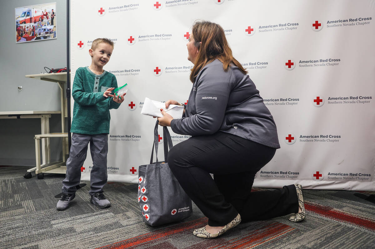 Henry Williams, 6, left, talks to Rachel Flanigan, executive director of the Red Cross of South ...