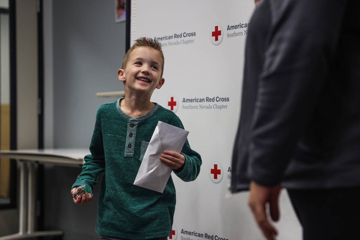 Henry Williams, 6, left, talks to Rachel Flanigan, executive director of the Red Cross of South ...