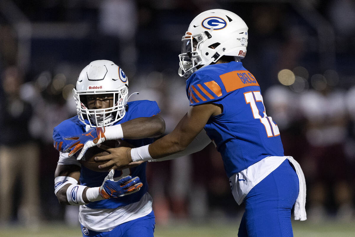 Bishop Gorman quarterback Micah Alejado (13) passes the ball to running back DeVon Rice (3) dur ...