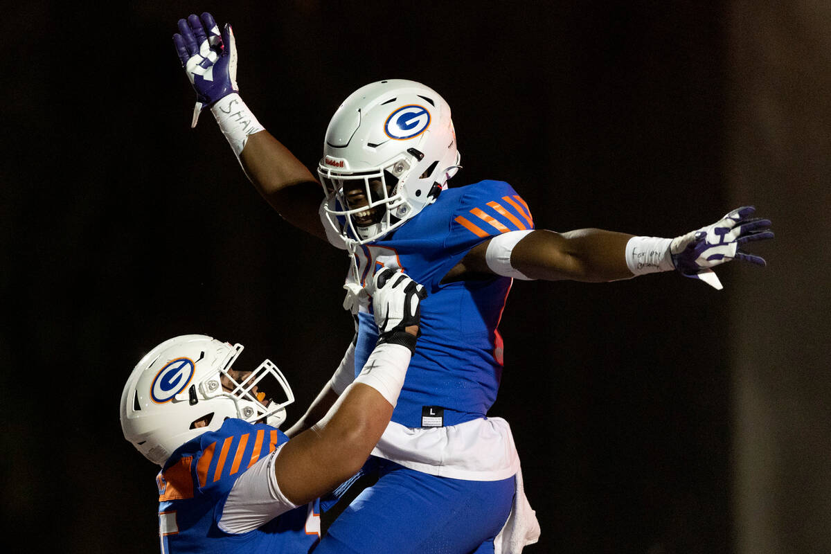 Bishop Gorman’s Joseph Micatrotto (55) lifts up Jett Washington (88) after Washington sc ...