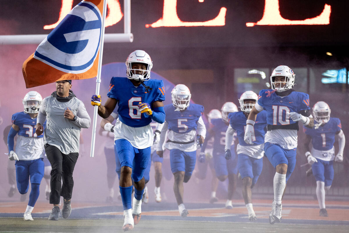 Bishop Gorman’s Jeremiah Hughes (6) leads his team onto the field before a high school f ...