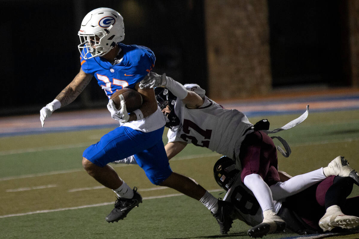 Bishop Gorman’s Trech Kekahuna (23) evades tackle by Faith Lutheran’s Brandon Soa ...