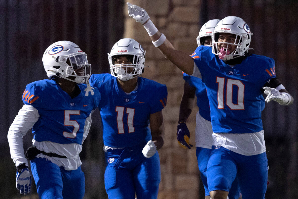 Bishop Gorman’s Jeremiah Vessel (5), Quincy Davis (11) and Palaie Faoa (10) celebrate a ...