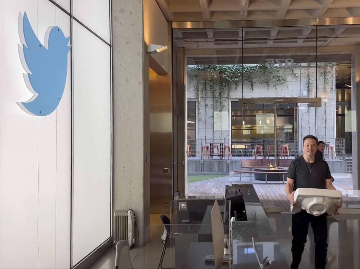 This image from the Twitter page of Elon Musk shows Musk entering Twitter headquarters carrying ...