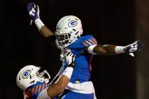 Bishop Gorman’s Joseph Micatrotto (55) lifts up Jett Washington (88) after Washington sc ...