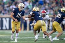 Notre Dame quarterback Drew Pyne (10) hands the ball off to *Notre Dame running back Logan Digg ...