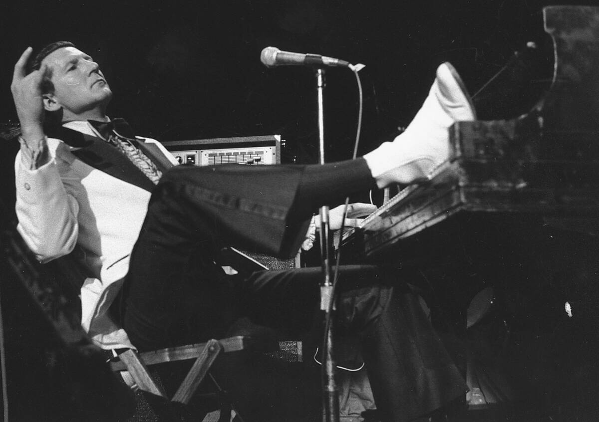 FILE - Jerry Lee Lewis props his foot on the piano as he lays back and acknowledges the applaus ...