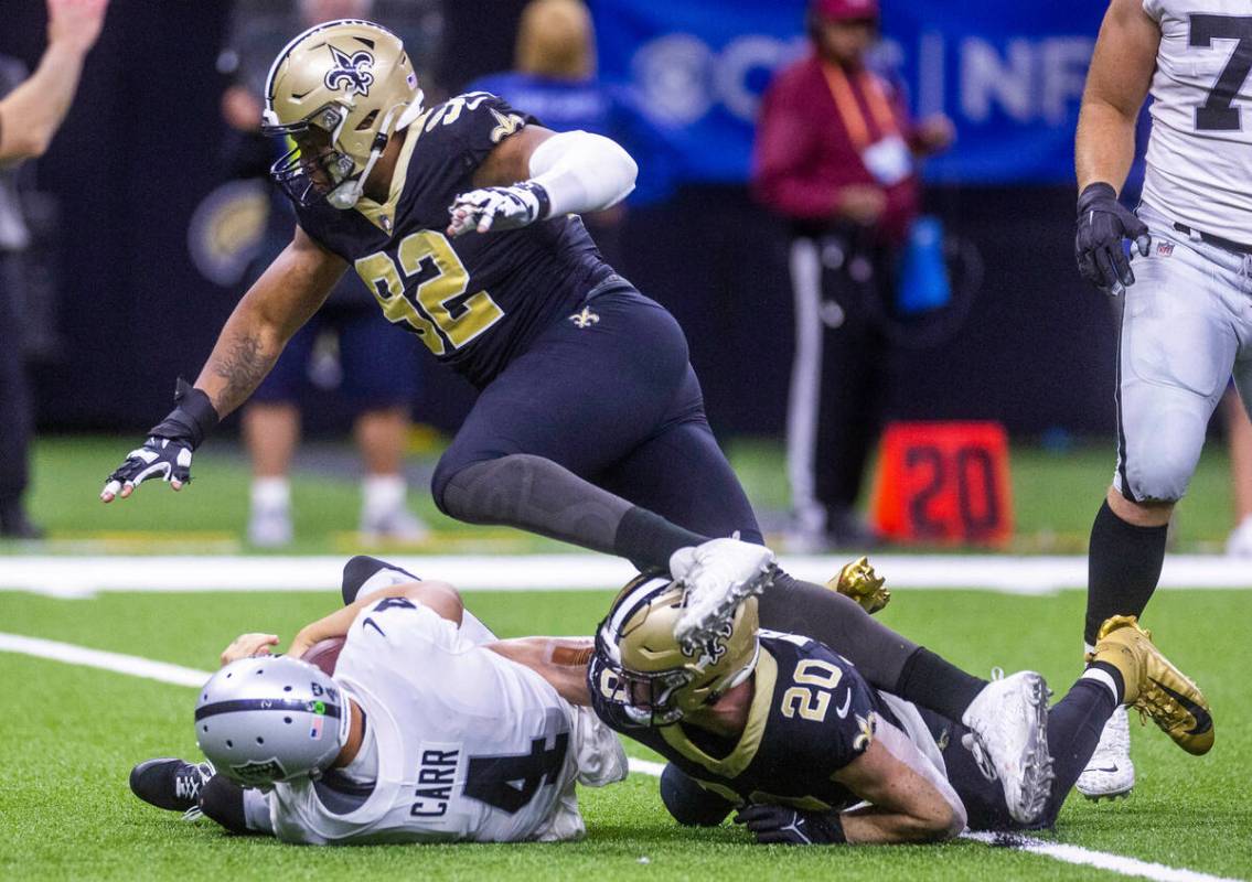 Raiders quarterback Derek Carr (4) is sacked by New Orleans Saints defensive end Marcus Davenpo ...