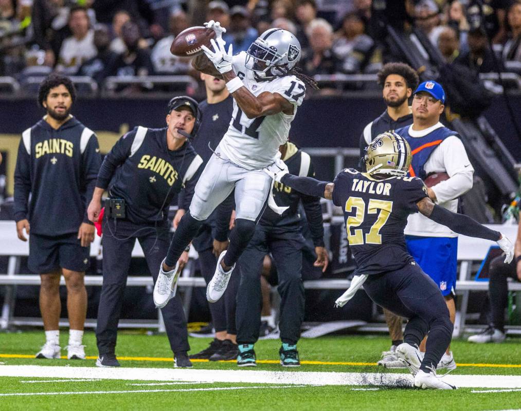 Raiders wide receiver Davante Adams (17) bobbles a deep pass along the sidelines with coverage ...