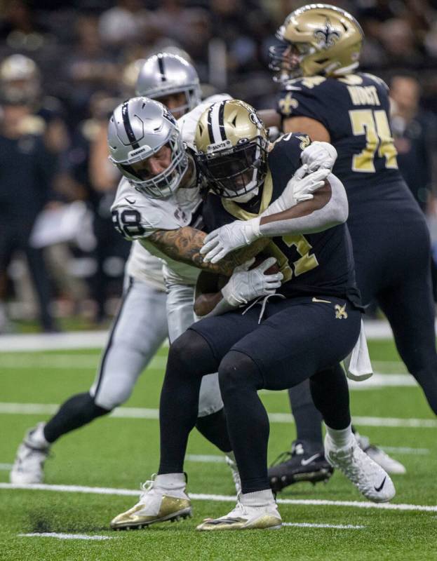 Raiders defensive end Maxx Crosby (98) tackles New Orleans Saints running back Alvin Kamara (41 ...