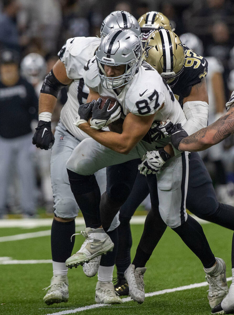 Raiders tight end Foster Moreau (87) looks for room to run as he is tackled by New Orleans Sain ...