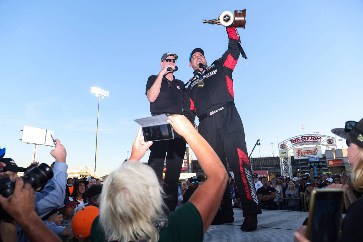 NHRA announcer Alan Reinhart stands with Matt Hagan as he greets the crowd after winning the fu ...