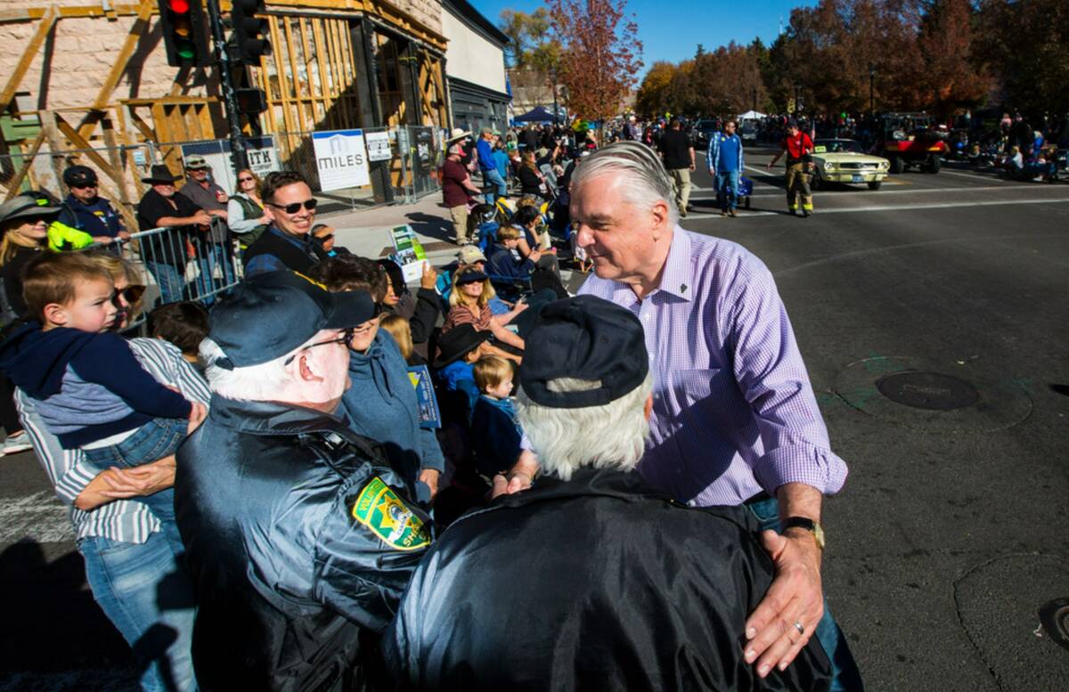 Gov. Steve Sisolak greets Dan Dulong, left, and Fred Webb, volunteers with the Carson City Sher ...