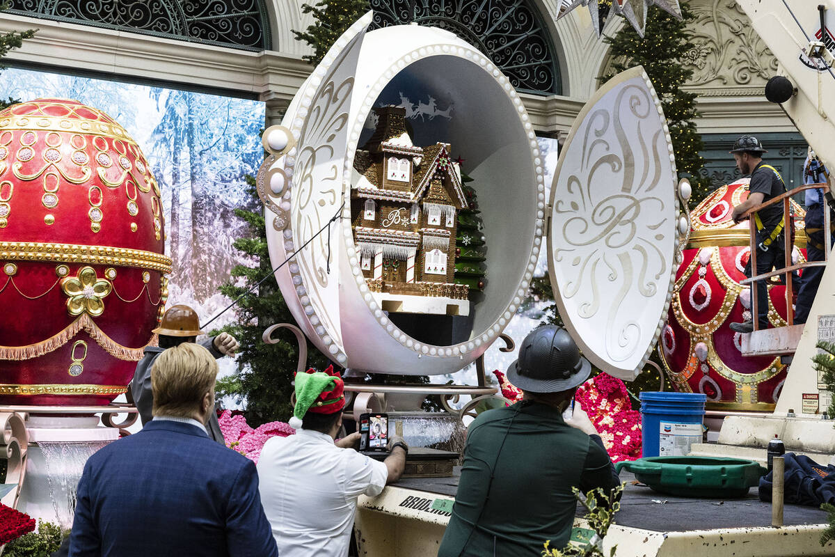 People watch as workers place the gingerbread house in the Bellagio Conservatory and Botanical ...