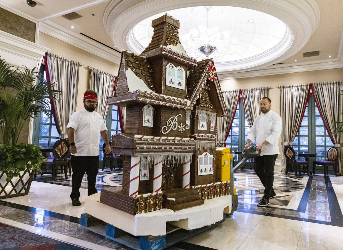 Philippe Angibeau, executive pastry chef at Bellagio, wheels the gingerbread house through the ...