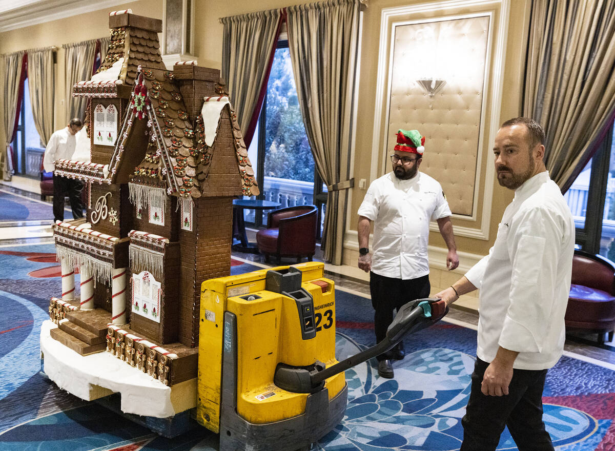 Philippe Angibeau, executive pastry chef at Bellagio, wheels the gingerbread house through the ...